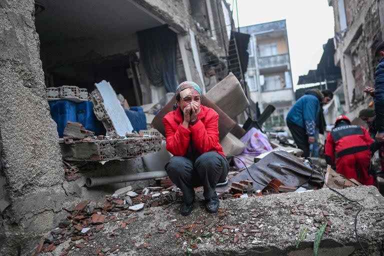 Un sobreviviente del terremoto reacciona mientras los rescatistas buscan víctimas y otros sobrevivientes
(Photo by BULENT KILIC / AFP)