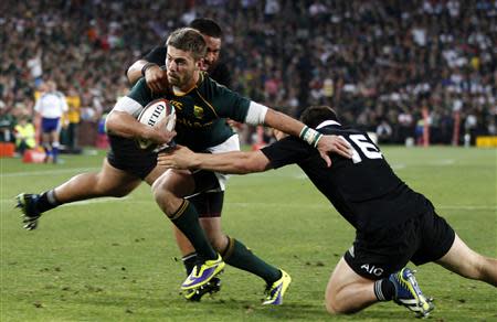 South Africa's Willie le Roux (C) is challenged by New Zealand's All Blacks Dane Coles (R) and Steven Luatua during the final round of the Rugby Championship at Ellis Park stadium in Johannesburg October 5, 2013. REUTERS/Siphiwe Sibeko