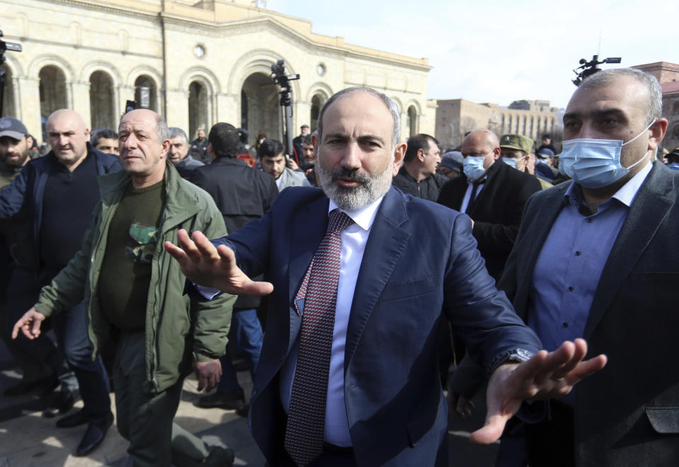 Armenian Prime Minister Nikol Pashinyan greets his supporters as he arrives at the main square in Yerevan, Armenia, Thursday, Feb. 25, 2021. Armenia's prime minister has spoken of an attempted military coup after facing the military's General Staff demand to step down. The developments come after months of protests sparked by the nation's defeat in the Nagorno-Karabakh conflict with Azerbaijan. (Stepan Poghosyan/PHOTOLURE via AP)