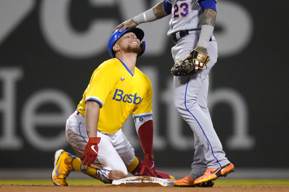 Boston Red Sox catcher Christian Vazquez, left, gets a congratulatory pat on the head by New York Mets second baseman Javier Baez (23) after his RBI double in the fourth inning of a baseball game at Fenway Park, Tuesday, Sept. 21, 2021, in Boston. (AP Photo/Charles Krupa)
