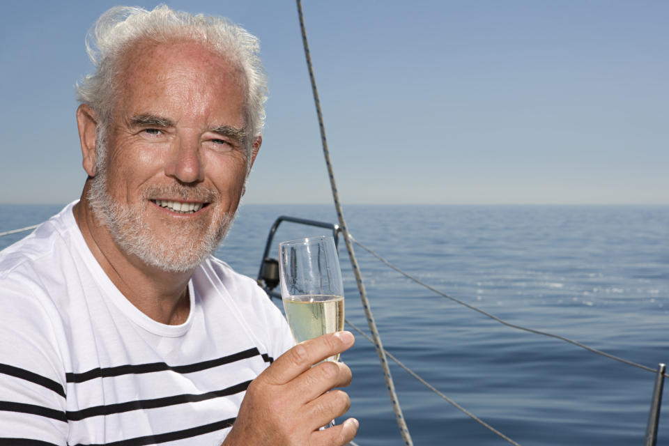 Older man out on the water holding a champagne glass