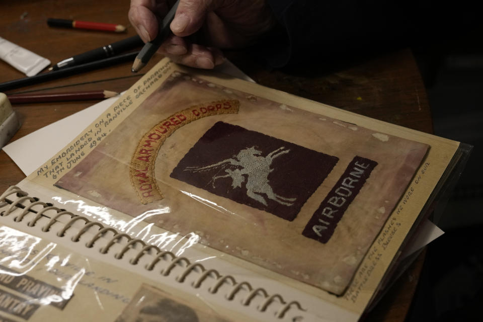 D-Day veteran Bill Gladden shows a page in his scrap book, which is a piece of parachute that he embroidered with the Airborne logo, as he speaks at his home in Haverhill, England, Friday, Jan. 12, 2024. Gladden spoke to the AP on the eve of his 100th birthday, he is a veteran of the 6th Airborne Armoured Reconnaissance Regiment, part of the British 6th Airborne Division, he landed by glider on the afternoon of D-Day, 6th June 1944 in Normandy. (AP Photo/Alastair Grant)