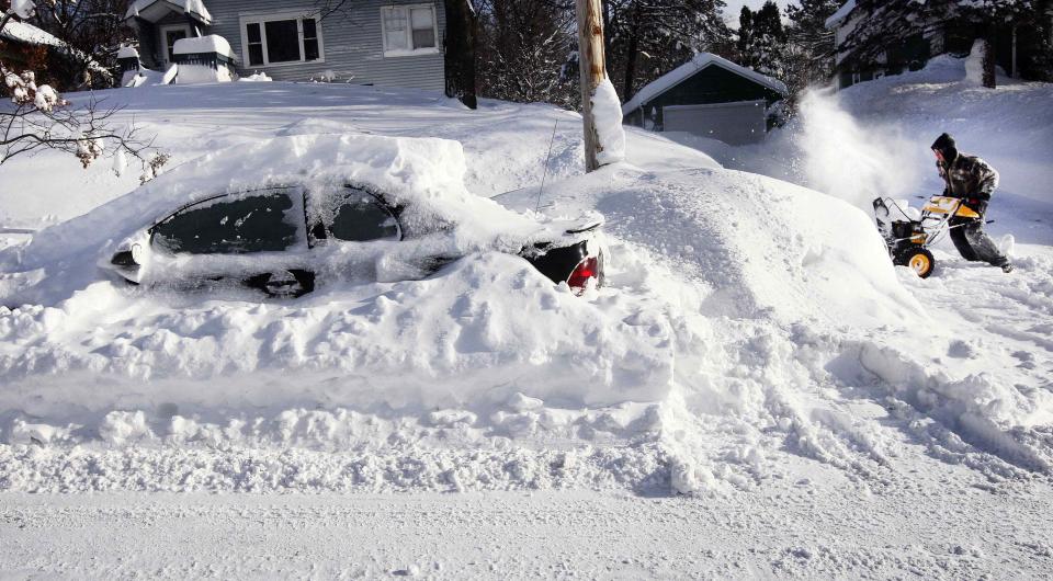 Scott Asperheim runs his snowblower to clear his driveway after a snowstorm in Duluth