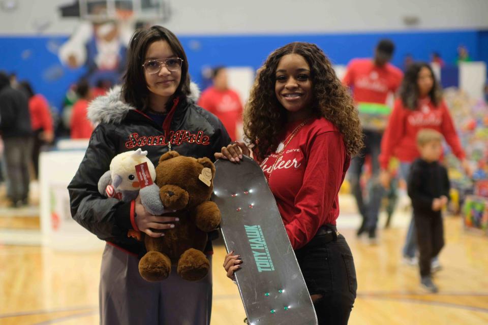 Tyra Combs, a volunteer, helps to choose a skateboard Saturday at the 10th annual Northside Toy Drive held at the Palo Duro High School Gym in Amarillo.