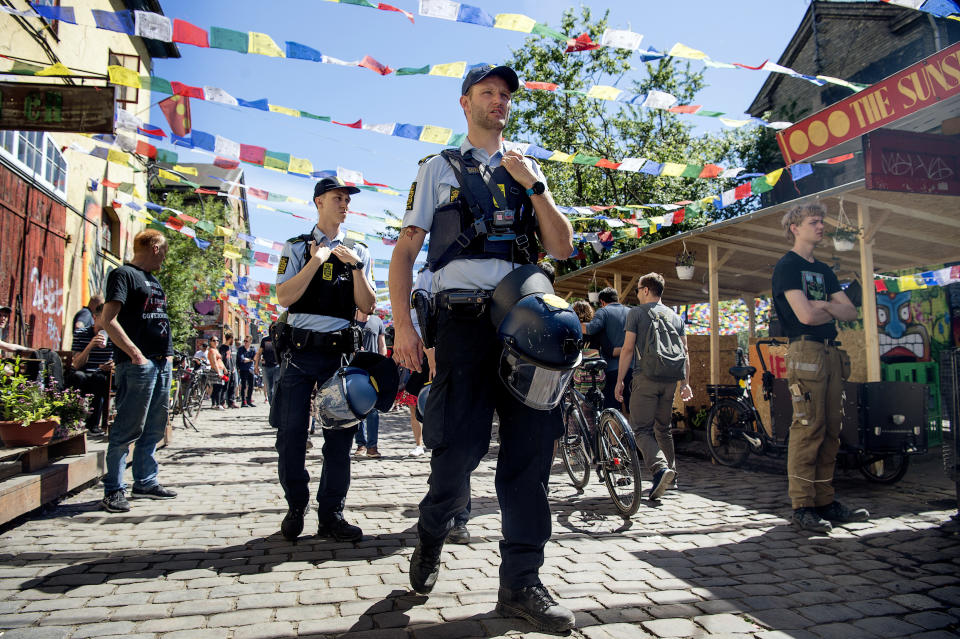 FILE - Police patrol Pusher Street in at Christiania, Copenhagen, Friday, May 25, 2018, after the street reopened after having been closed for three days. Copenhagen’s mayor is urging urged foreigners not to buy weed in a the city's Christiania neighborhood known for its flourishing hashish trade where a 30-year-old man was killed by shots last month and four people injured. (Nils Meilvang/Ritzau Scanpix via AP, File)