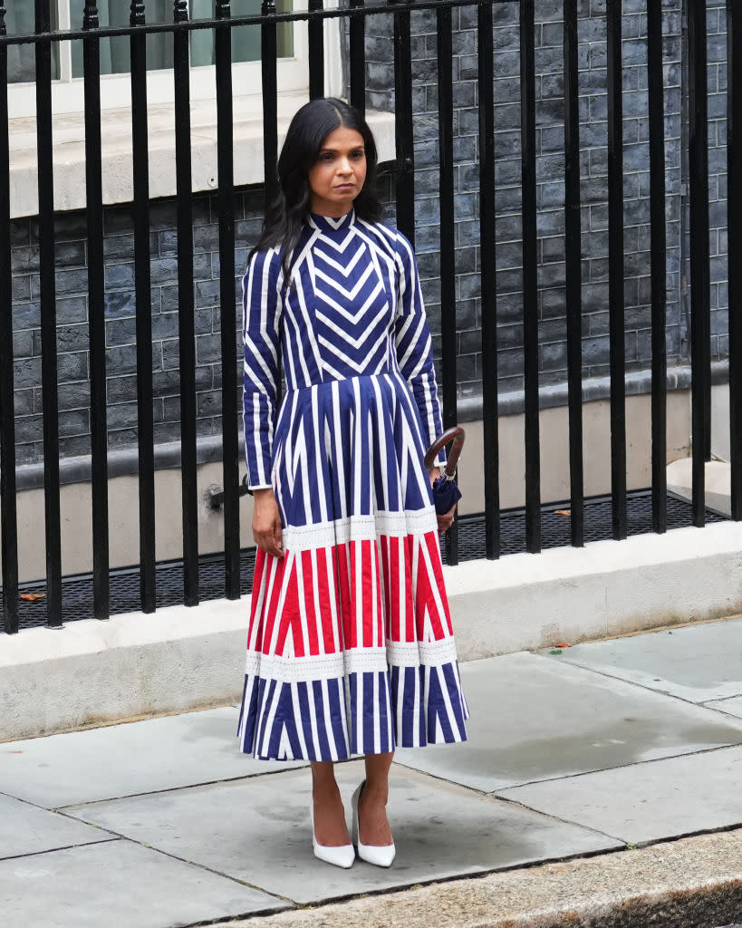 Prime Minister Rishi Sunak wife Akshata Murty outside 10 Downing Street looks on as they leave 10 Downing Street. She wore a ka-sha dress in the colors of the united kingdom flag in blue red and white.