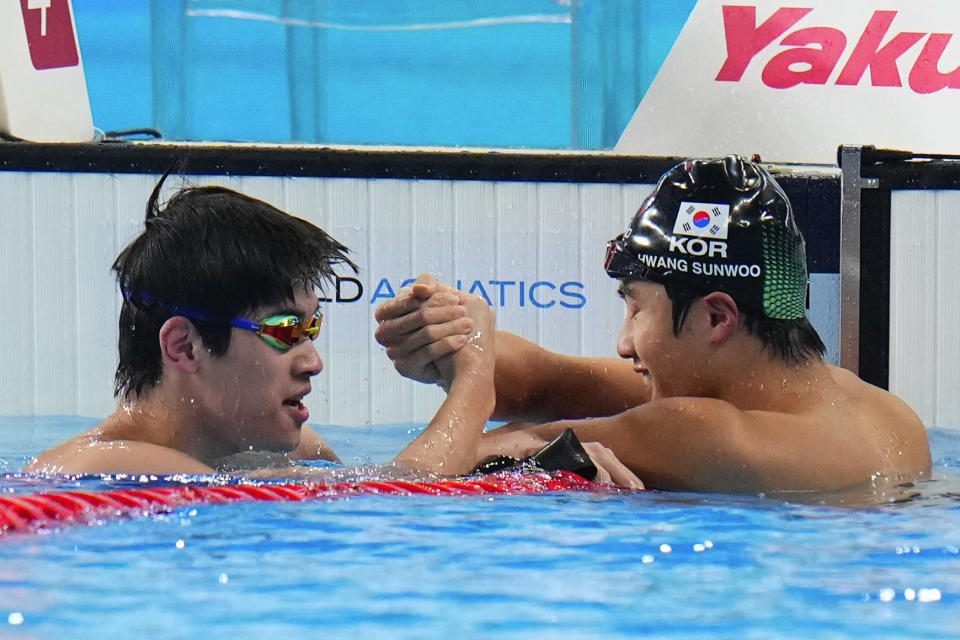 Zhanle Pan of China , left, compliments Hwang Sun-woo of South Korea after Pan won in the men's 100-meter freestyle final at the World Aquatics Championships in Doha, Qatar, Thursday, Feb. 15, 2024. (AP Photo/Hassan Ammar)