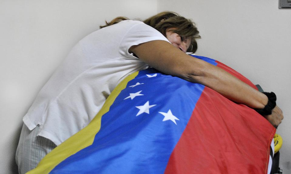 Carmen Gonzalez cries over the body of her son, Jimmy Vargas, a student who died during a protest, at a hospital in San Cristobal