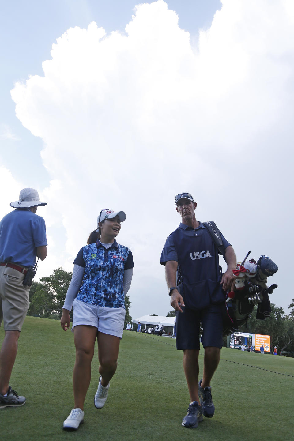 Moriya Jutanugarn of Thailand, walks off the course with caddie Phillip Lowe due to inclement weather during the second round of the U.S. Women's Open golf tournament, Friday, May 31, 2019, in Charleston, S.C. (AP Photo/Steve Helber)