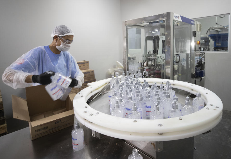 A worker produces hand sanitizer at the Companhia Nacional do Álcool (CNA) factory in Piracicaba, Brazil, Tuesday, March 3, 2020. Last week the factory added a second shift of workers to produce more hand sanitizer, and while the CNA was never an exporter, it's considering that by adding a third shift. One week ago, Brazil confirmed Latin America’s first case of the new coronavirus. (AP Photo/Andre Penner)