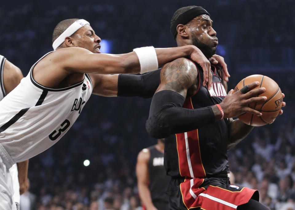 Brooklyn Nets forward Paul Pierce (34) fouls Miami Heat forward LeBron James (6) as he drives through the lane to score in the first period during Game 3 of an Eastern Conference semifinal NBA playoff basketball game on Saturday, May 10, 2014, in New York. Pierce was called for a flagrant foul and James scored on the play. (AP Photo/Julie Jacobson)