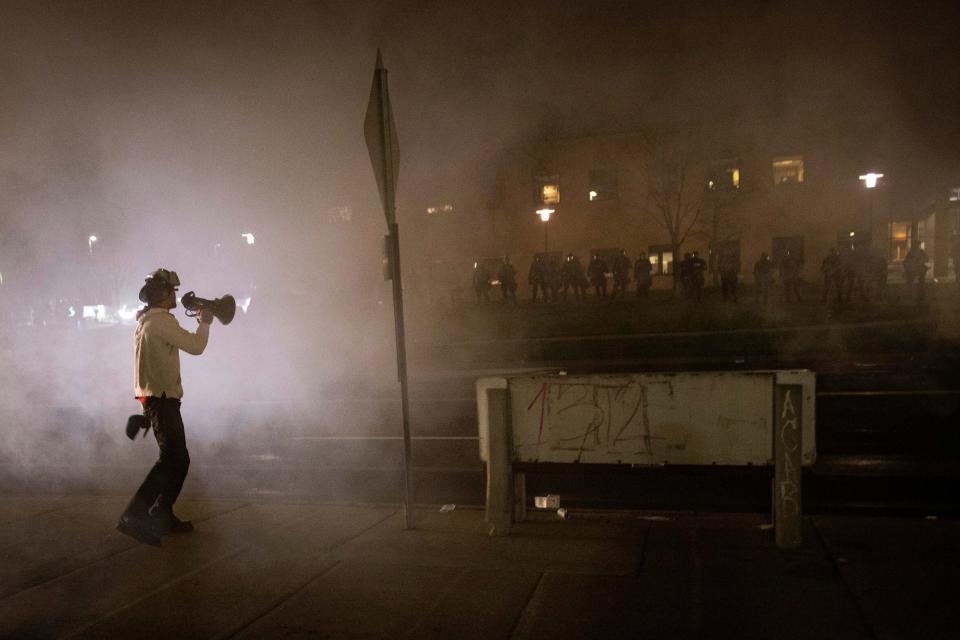 A protester confronts police in front of the Brooklyn Center Police station on Sunday, April 11, 2021, in Brooklyn Center, Minnesota.