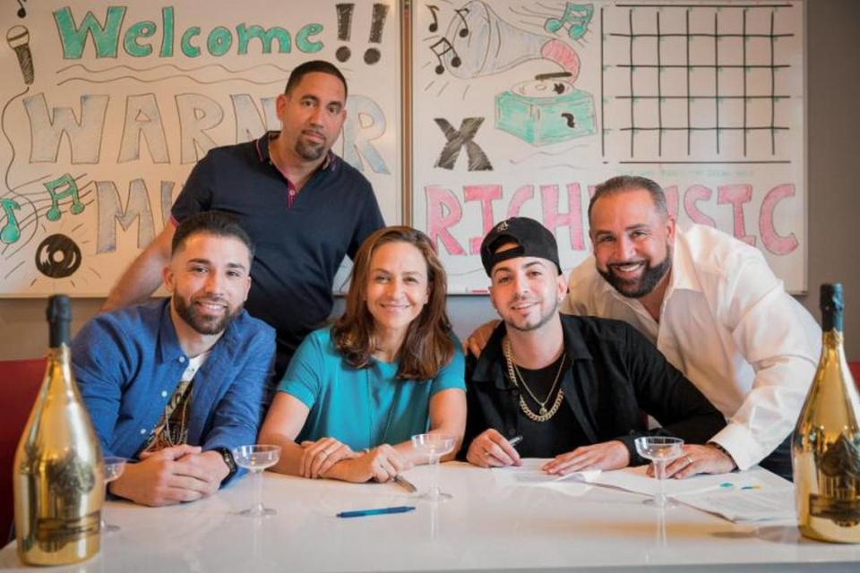 Reggaetón artist Justin Quiles, second from right, signed a deal with Warner Music in 2017. At right is Rich Mendez, the owner of Miami’s Rich Music.