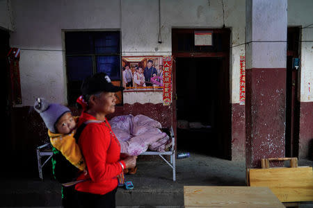 An ethnic Lisu woman carries her grandson in her village in Nujiang Lisu Autonomous Prefecture in Yunnan province, China, March 24, 2018. REUTERS/Aly Song