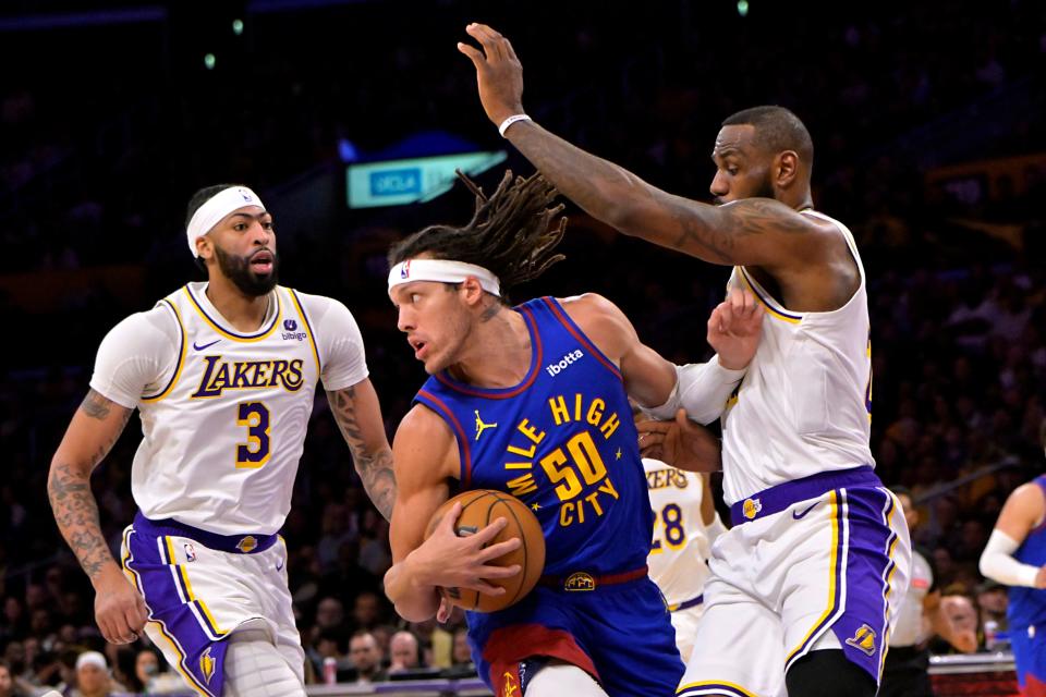 Denver Nuggets forward Aaron Gordon (50) is defended by Los Angeles Lakers forward Anthony Davis (3) and forward LeBron James (23) at Crypto.com Arena.