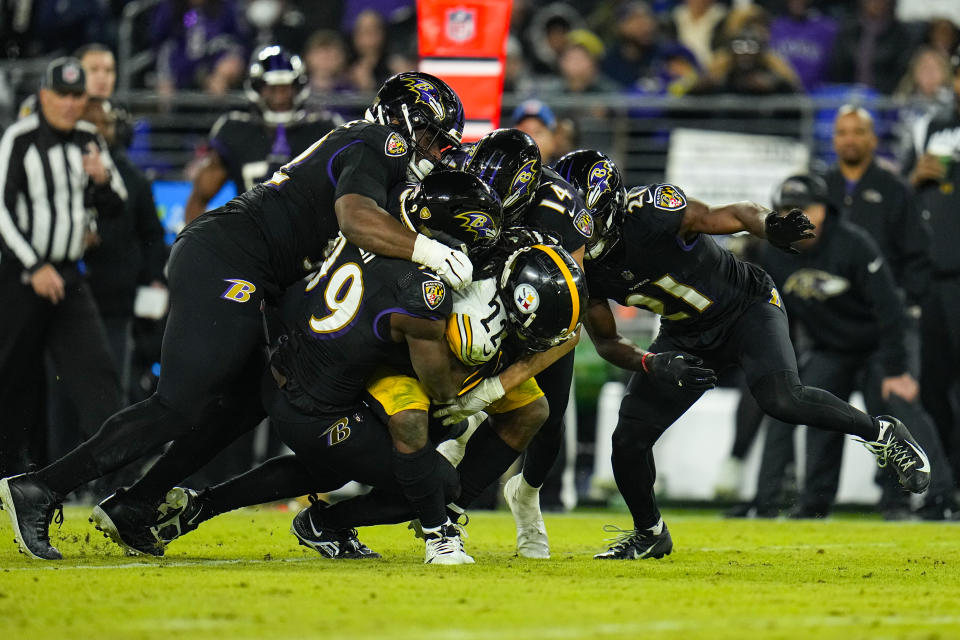 Pittsburgh Steelers running back Najee Harris (22) is tackled by the Baltimore Ravens including linebacker Odafe Oweh (99) and safety Kyle Hamilton (14) in the second half of an NFL football game in Baltimore, Fla., Sunday, Jan. 1, 2023. (AP Photo/Julio Cortez)