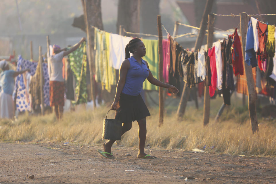 A woman carries a bucket after doing her laundry in Harare, Friday, 9, 2019. Fuel prices and the cost of living continue to rise in Zimbabwe due to the volatility of the recently introduced new currency, as the population struggles with water and power shortages. (AP Photo/Tsvangirayi Mukwazhi)