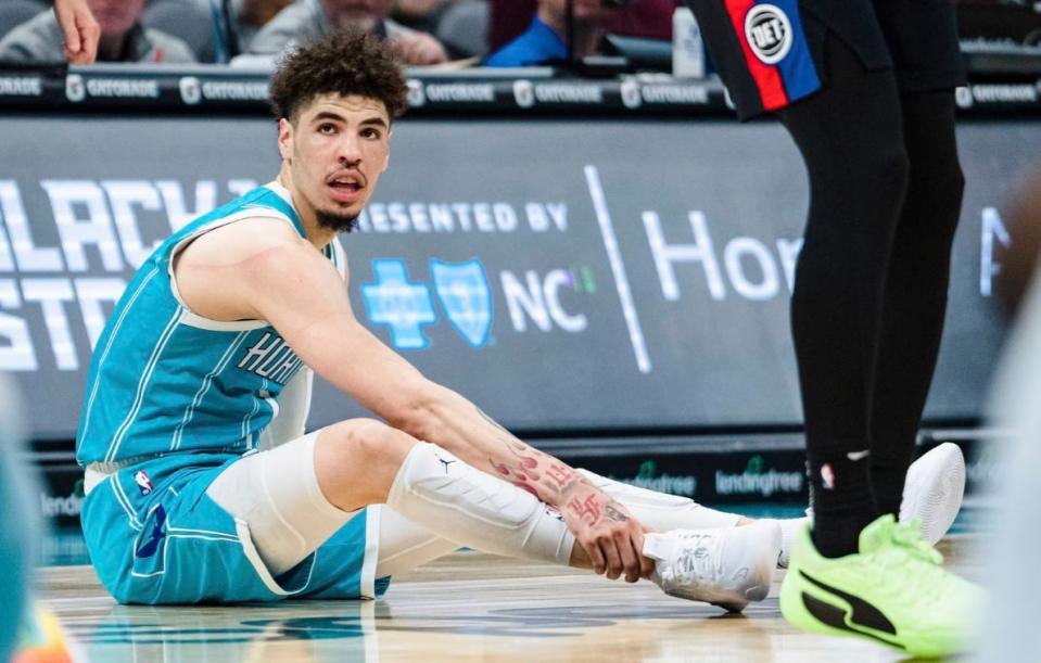 Charlotte Hornets guard LaMelo Ball holds his ankle after being shaken up on a play during the second half of an NBA basketball game against the Detroit Pistons in Charlotte, N.C., Monday, Feb. 27, 2023. (AP Photo/Jacob Kupferman)