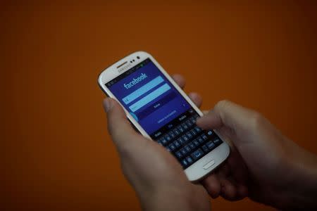 A smartphone user logs into his Facebook account in Rio de Janeiro April 15, 2013. REUTERS/Ricardo Moraes