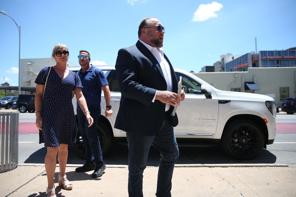 Alex Jones arrives at the Sweatt Travis County Courthouse with his wife, Erika Wulff Jones, and his security detail on Tuesday.