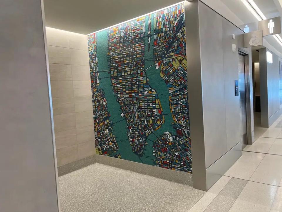 The green mosaic art leading into the bathrooms.