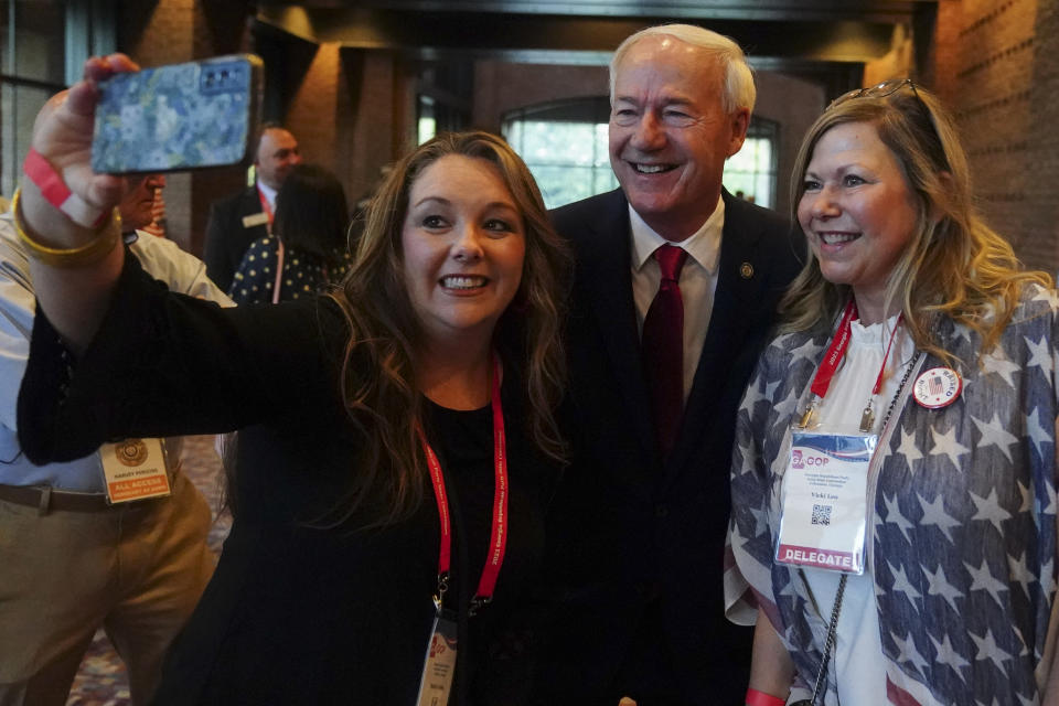 Former Arkansas Gov. Asa Hutchinson takes a photo with people attending the the Georgia Republican convention, Saturday, June 10, 2023, in Columbus, Ga. (AP Photo/John Bazemore)