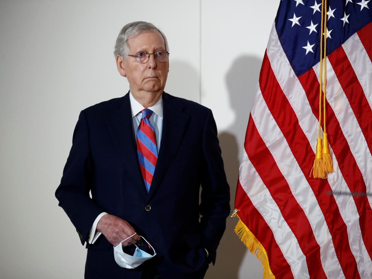 Senate Majority Leader Mitch McConnell of Ky., holds a face mask used to protect against the spread of the new coronavirus as he attends a news conference on Capitol Hill in Washington, Tuesday, May 12, 2020. (AP Photo/Patrick Semansky)