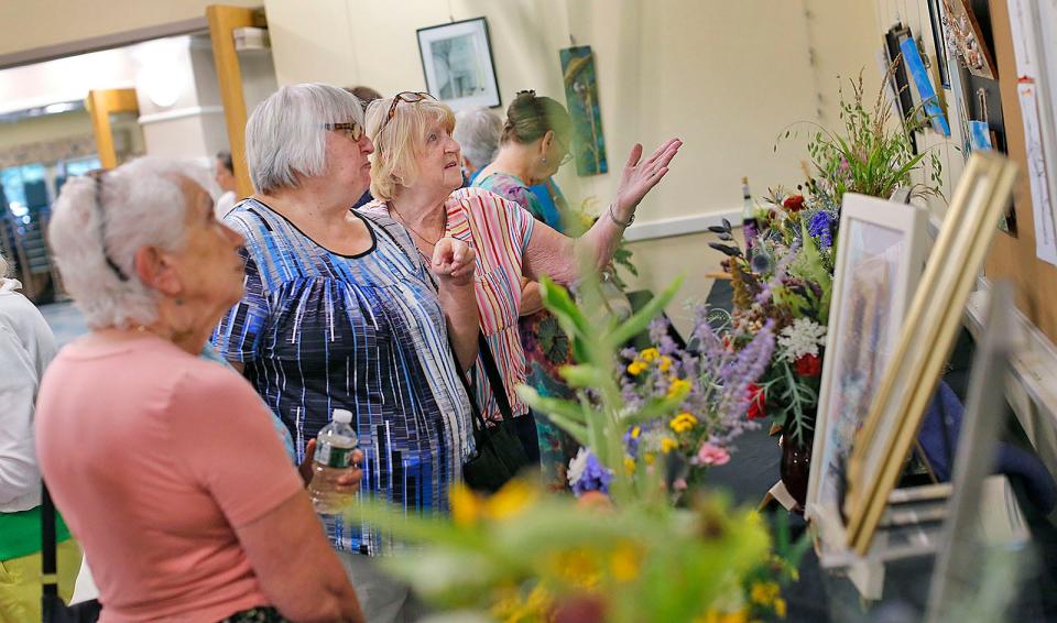 "Art in Bloom" brings local florists and artists together. Members of the Seaside Gardeners, a local club, recreate works of art by students at the Marshfield Senior Center through flower arrangements.