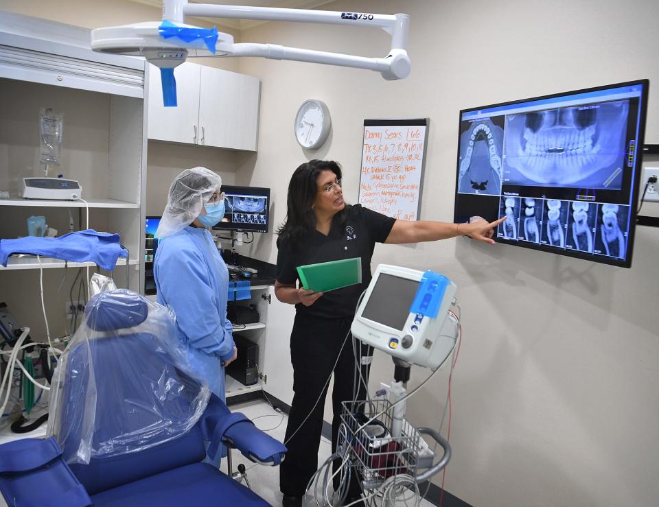 Dr. Sandra Vergara, right, talks with registered dental assistant Abrien Bradford about a patient's oral surgery case. Vergara is hosting an open house at her new location at 2186 Kell West Blvd. which she opened during the pandemic.