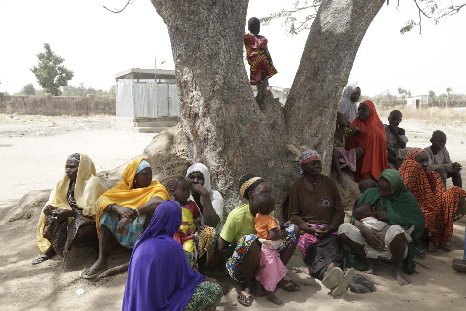 In this photo taken on Monday, Feb. 18, 2019, Woman and Children displaced by Islamist extremist sits under a tree at Malkohi camp in Yola, Nigeria. For those who live in the makeshift camp for Nigerians who have fled Boko Haram violence, the upcoming presidential vote isn’t a topic of conversation, because nearly all are more worried about putting food on the table.(AP Photo/ Sunday Alamba)