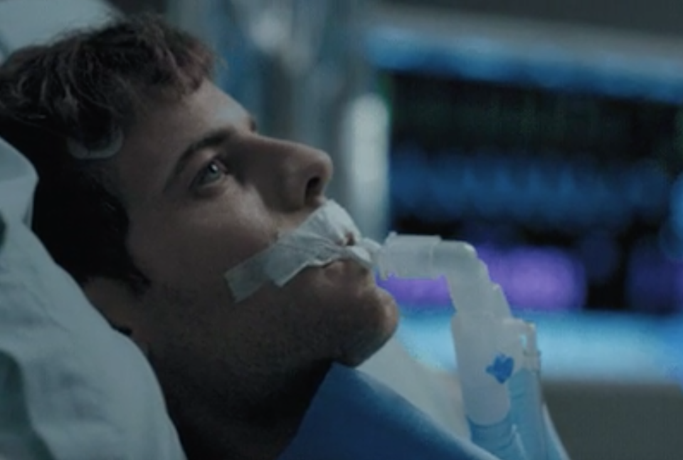 Close-up of a person in bed with a breathing tube in their mouth