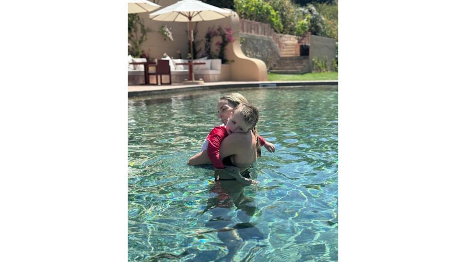 mother hugging son in swimming pool 