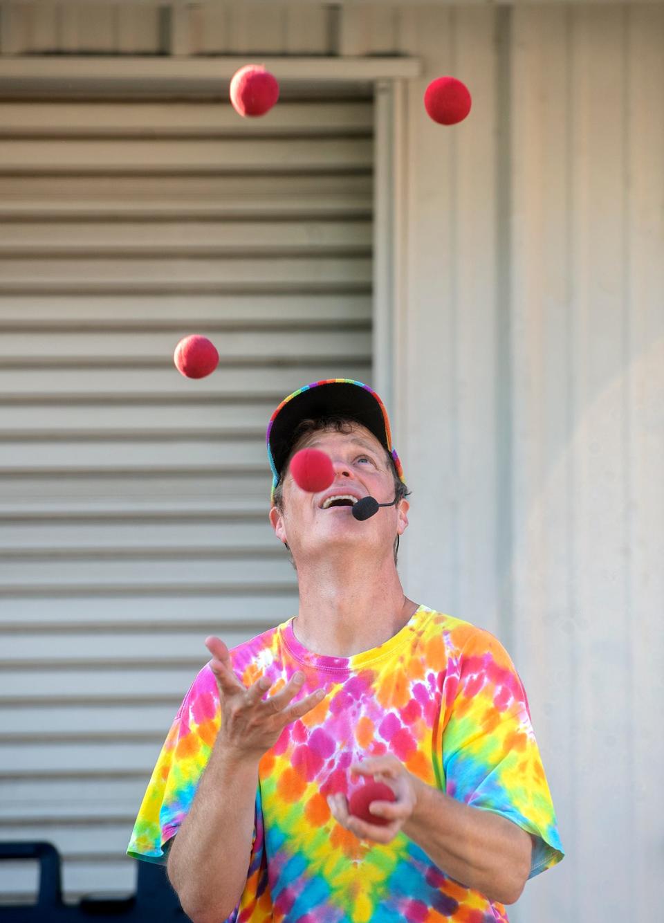 Juggler Jeremy Schafer tosses balls in the air as he entertains passersby on the midway at the San Joaquin County Fairgrounds in Stockton for the opening day of the county fair in Stockton on Friday, June 2, 2023. A number of murals were created by various groups to be placed around the fairgrounds during the 3 day run of the fair.