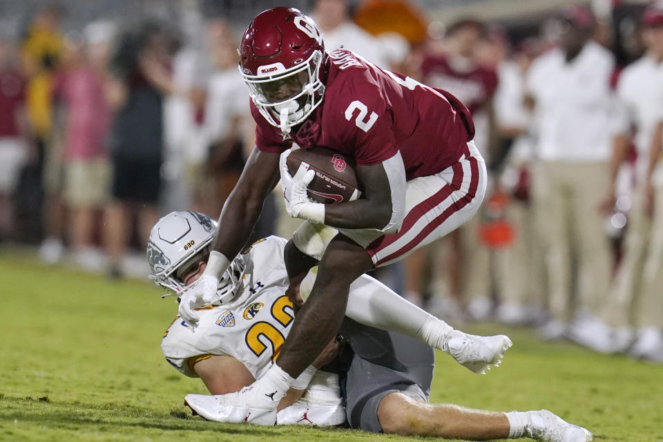 Oklahoma running back Jovantae Barnes (2) fights off a tackle from Kent State safety Gage Michael, left, in the second half of an NCAA college football game, Saturday, Sept. 10, 2022, in Norman, Okla. AP Photo/Sue Ogrocki