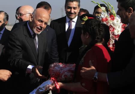 A Pakistani girl presents flowers to visiting Afghan President Ashraf Ghani after his arrival at Chaklala Airbase in Rawalpindi near Islamabad November 14, 2014. REUTERS/Faisal Mahmood