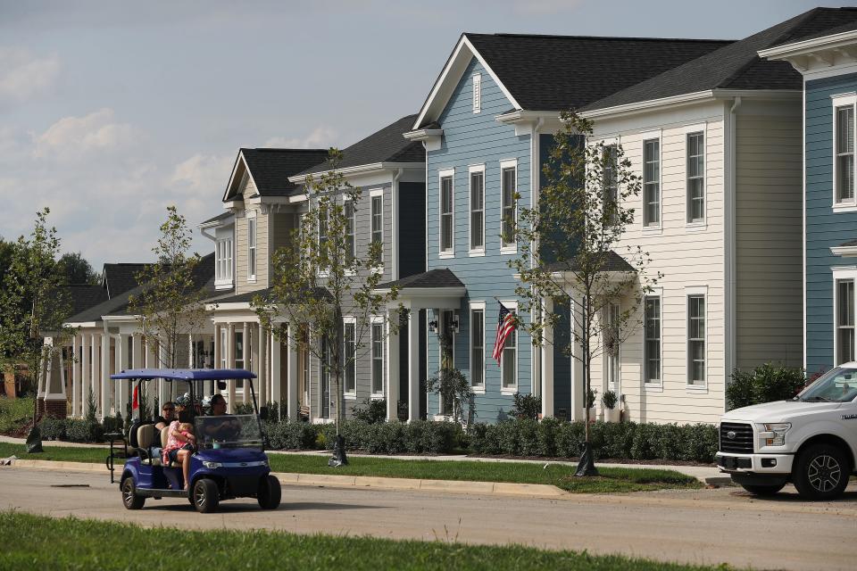 People in a golf cart rode past a row of private homes and homes for sale in the North Village of Norton Commons in Louisville, Ky. on Sep. 5, 2021.  The neighborhood continues to grow after it was constructed 15 years ago.