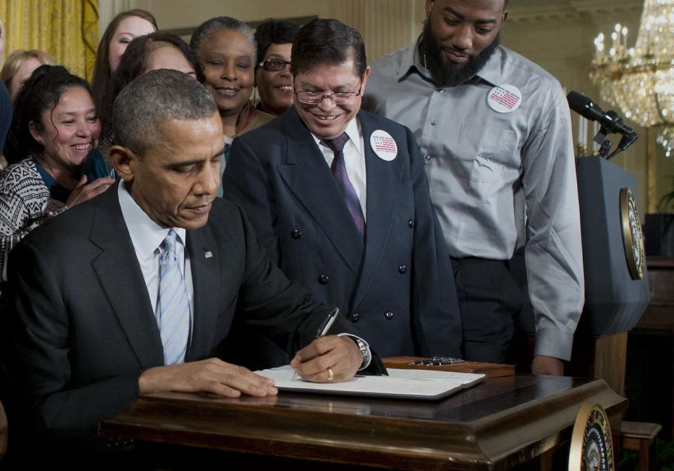 FILE - This Feb. 12, 2014 file photo shows President Barack Obama signing an executive order to raise the minimum wage for federal contract workers during a ceremony in the East Room of the White House in Washington. Most Americans with intellectual or developmental disabilities remain shut out of the workforce, despite changing attitudes and billions spent on government programs to help them. Even when they find work, it’s often part time, in a dead-end job or for pay well below the minimum wage. (AP Photo/Pablo Martinez Monsivais, File)