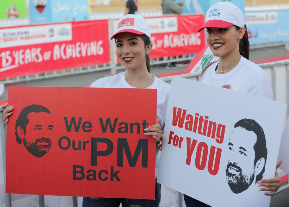 Hariri supporters at Beirut's annual marathon on Sunday hold up signs&nbsp;seeking his return to Lebanon. (Photo: ANWAR AMRO via Getty Images)