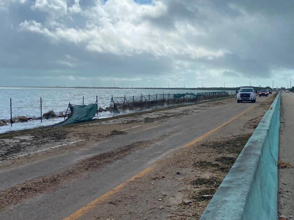 Fencing is blown out and seaweed strewn on the roadway of the 18 Mile Stretch of U.S. 1 in the Florida Keys Thursday, Nov. 16, 2023.