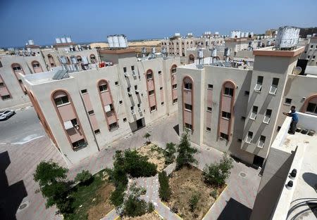 A Palestinian man stands on the rooftop of a building at a Japan-funded housing project executed by the United Nations Development Programme (UNDP), in Khan Younis in the southern Gaza Strip August 9, 2016. REUTERS/Ibraheem Abu Mustafa