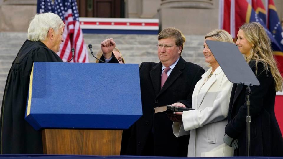 Mississippi Republican Gov. Tate Reeves recites the oath of office as he is sworn in to his second term, by Mississippi Supreme Court Chief Justice Michael Randolph, left, while his wife Elee Reeves, right, holds the family Bible during the inauguration ceremony in Jackson.