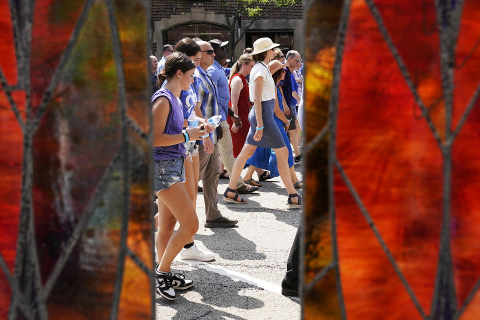 People participate in a community walk in Highland Park, Ill., Tuesday, July 4, 2023. One year after a shooter took seven lives at the city's annual parade, community members are planning to honor the victims and reclaim the space to move forward. (AP Photo/Nam Y. Huh)