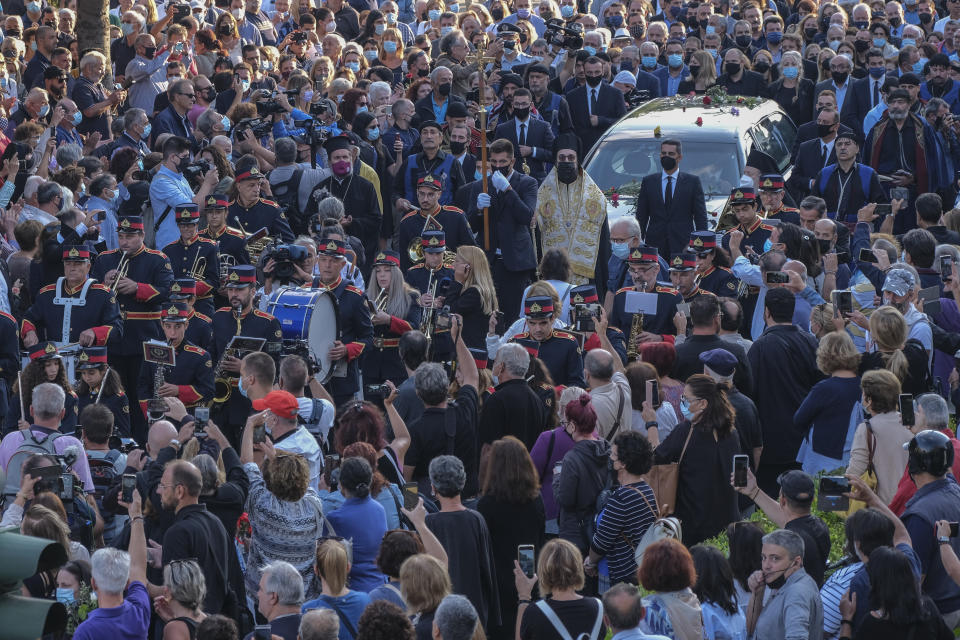 People gather to pay their last respect to the late Greek composer Mikis Theodorakis, as the hearse drives among the crowd, prior to his burial, in Chania, Crete island, Greece, Thursday, Sept. 9 2021. Theodorakis died Thursday, Sept. 2, 2021 at 96. He penned a wide range of work, from somber symphonies to popular TV and film scores, including for “Serpico” and “Zorba the Greek.” He is also remembered for his opposition to the military junta that ruled Greece from 1967-1974, when he was persecuted and jailed and his music outlawed. (AP Photo/Harry Nakos)