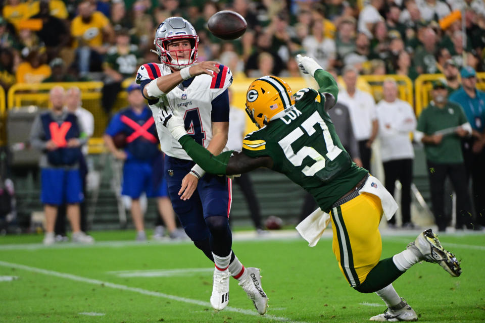 Aug 19, 2023; Green Bay, Wisconsin, USA; New England Patriots quarterback <a class="link " href="https://sports.yahoo.com/nfl/players/34093" data-i13n="sec:content-canvas;subsec:anchor_text;elm:context_link" data-ylk="slk:Bailey Zappe;sec:content-canvas;subsec:anchor_text;elm:context_link;itc:0">Bailey Zappe</a> (4) throws while under pressure from Green Bay Packers linebacker Brenton Cox (57) in the third quarter at Lambeau Field. Mandatory Credit: Benny Sieu-USA TODAY Sports