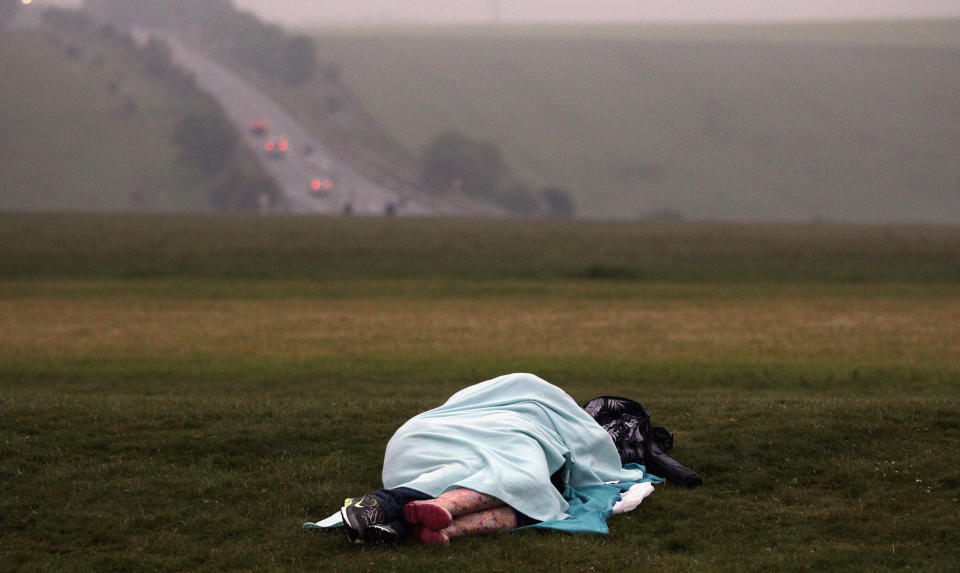 SALISBURY, ENGLAND - JUNE 21:  A couple sleep as  revelers celebrate the arrival of the midsummer dawn at the megalithic monument of Stonehenge on June 21, 2012 near Salisbury, England. (Photo by Matt Cardy/Getty Images)