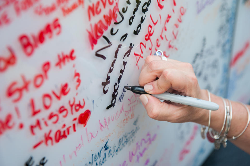 Angie Sola leaves a message on the Pulse memorial.