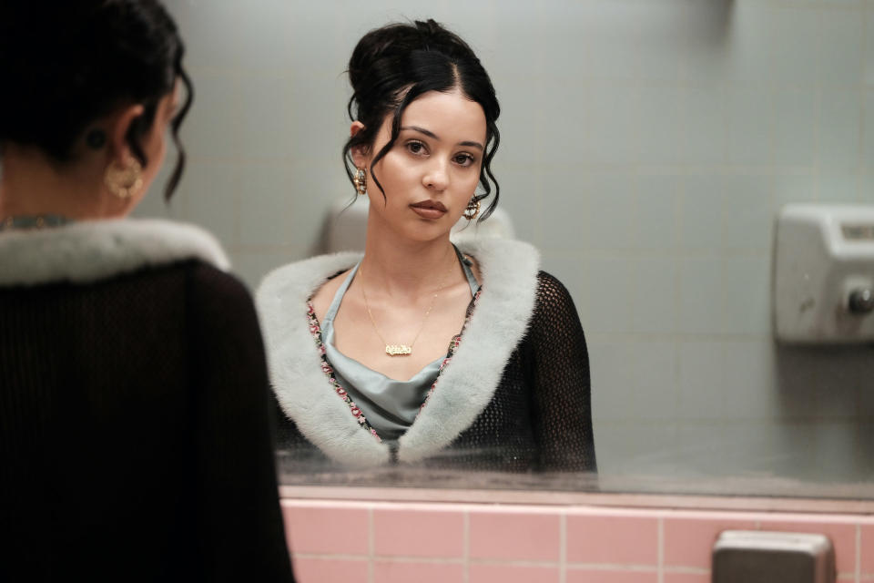 Maddy looking into a mirror in the school bathroom