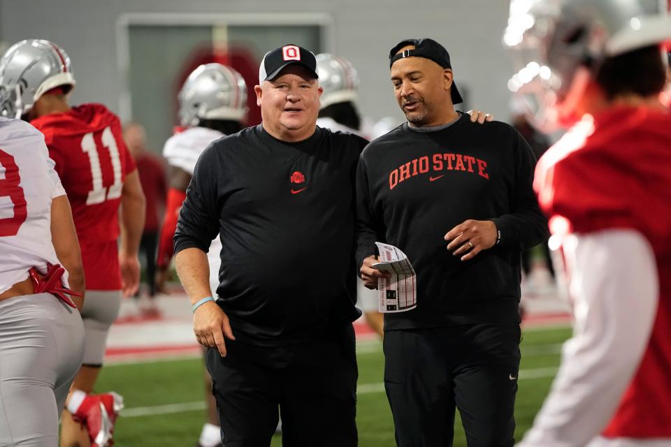 Ohio State secondary coach Tim Walton, right, talks with offensive coordinator Chip Kelly during spring practice.