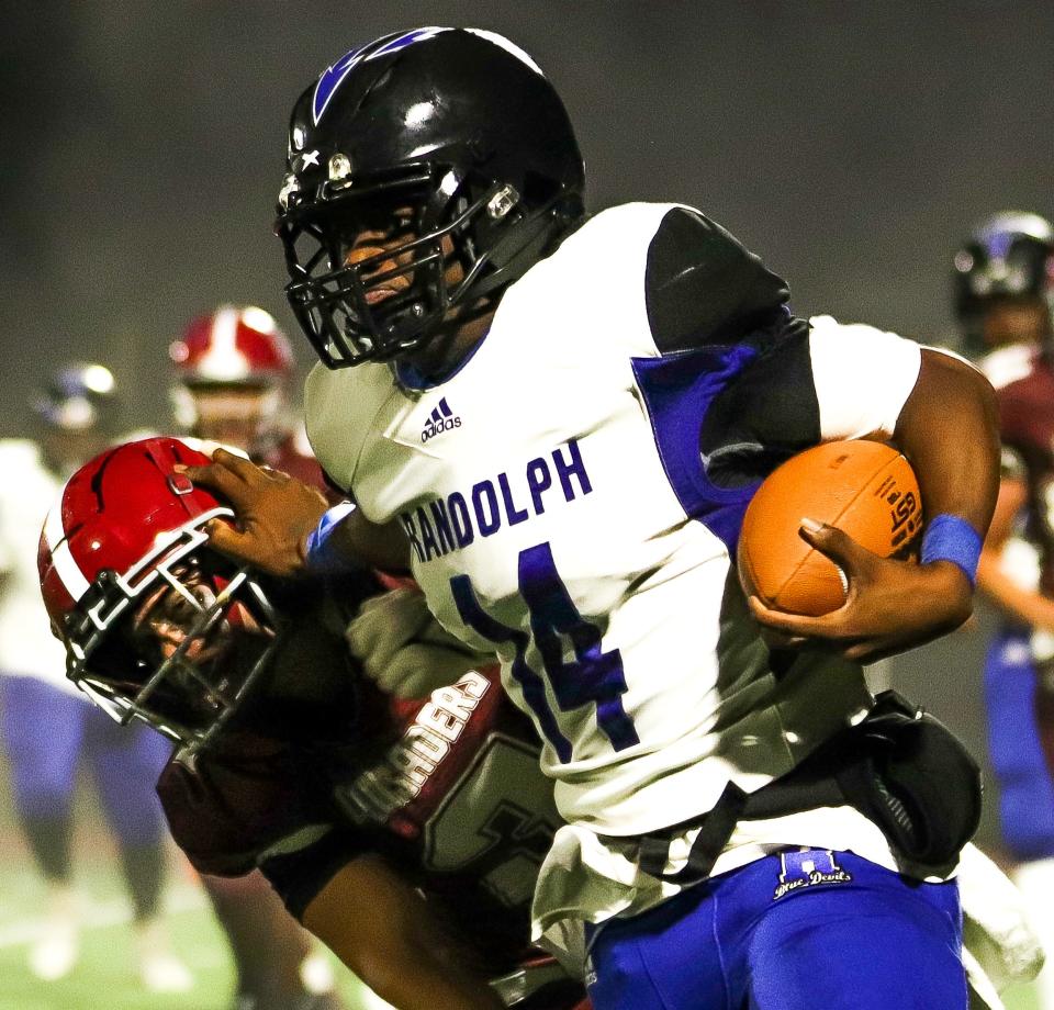 Randolph's Gardy Augustin stiff-arms a defender during a game against Carver on Thursday, Oct. 6, 2022. The Crusaders won 21-0.