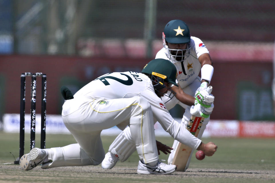Australia's Travis Head, left, attempts to take a catch of Pakistan's Babar Azam, on the fifth day of the second test match between Pakistan and Australia at the National Stadium in Karachi Pakistan, Wednesday, March 16, 2022. (AP Photo/Fareed Khan)